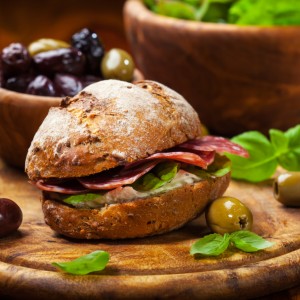 Sandwich with Italian salami, goat cheese and fresh olives